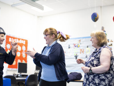 Students and school staff member taking part in drama activity in the classroom