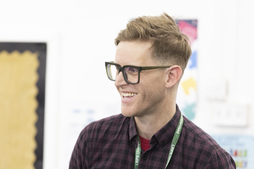 Brad smiling in a school classroom