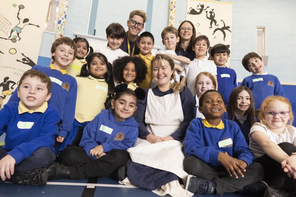 Cap-a-Pie team with pupils at Chillingham Road Primary School in a group smiling at the camera.