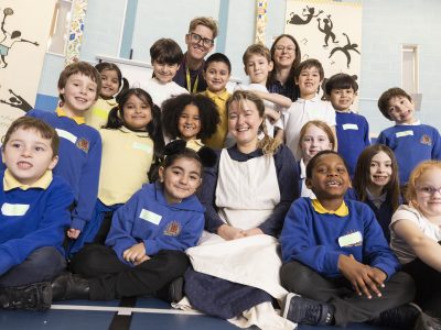 Cap-a-Pie team with pupils at Chillingham Road Primary School in a group smiling at the camera.