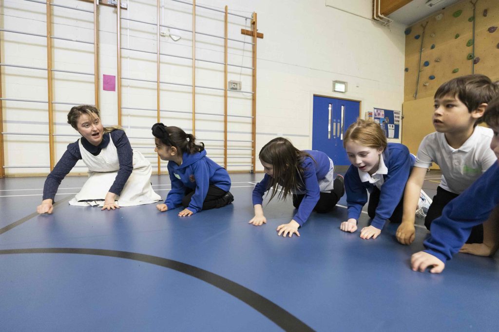 Jeannie interacting with group of childing during workshop in school hall