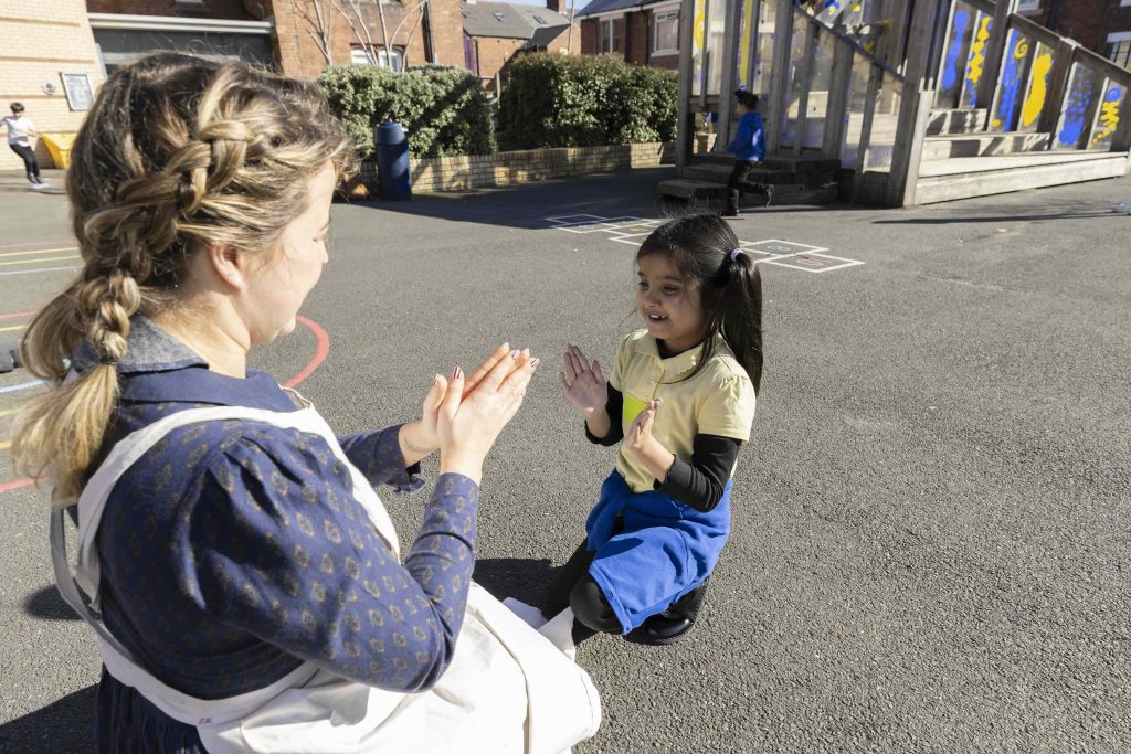 Jeannie playing a game with a pupil in the school playground